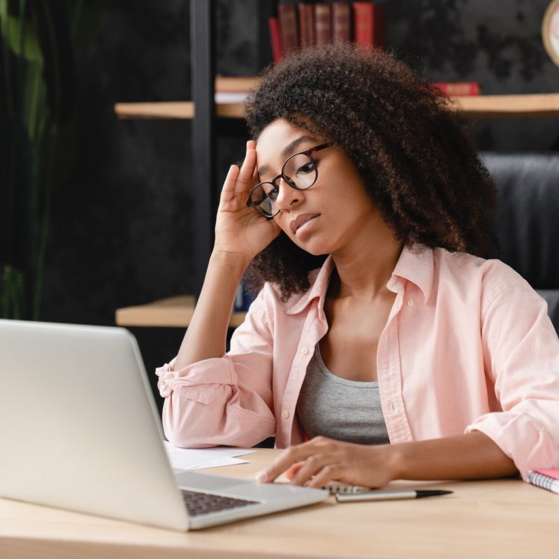 Freelancer having problems at work, suffering from headache, migraine at workplace office.