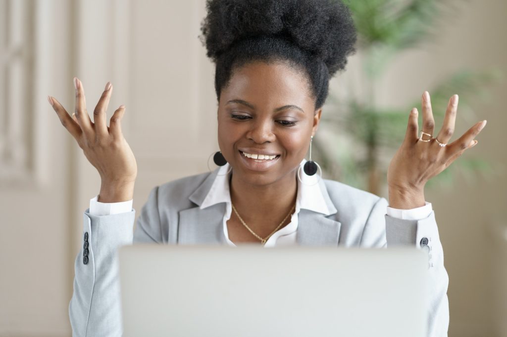 Smiling African business woman watching education webinar, talking on video chat or videoconference