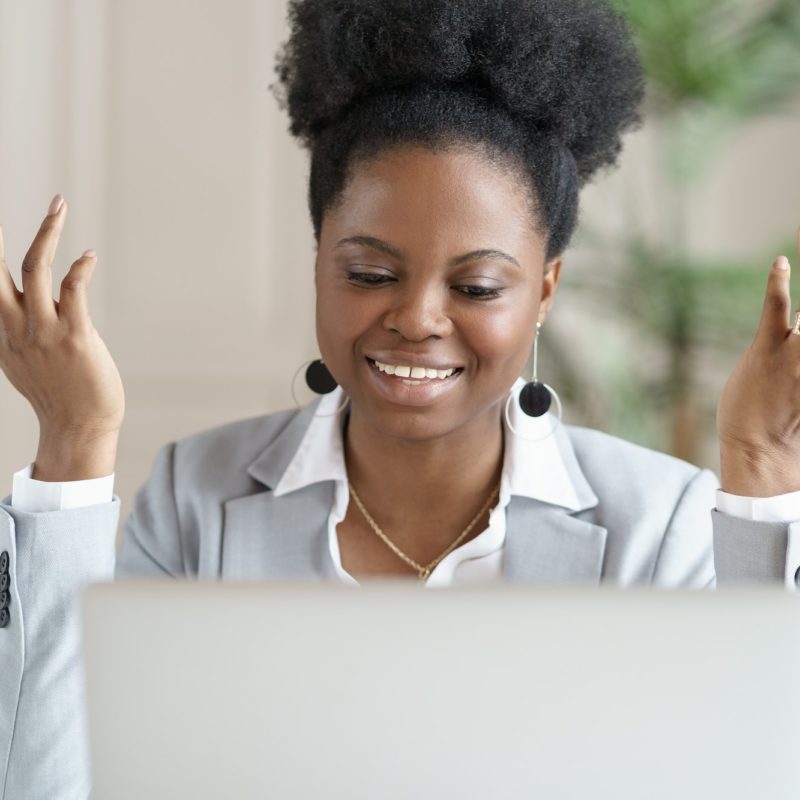 Smiling African business woman watching education webinar, talking on video chat or videoconference