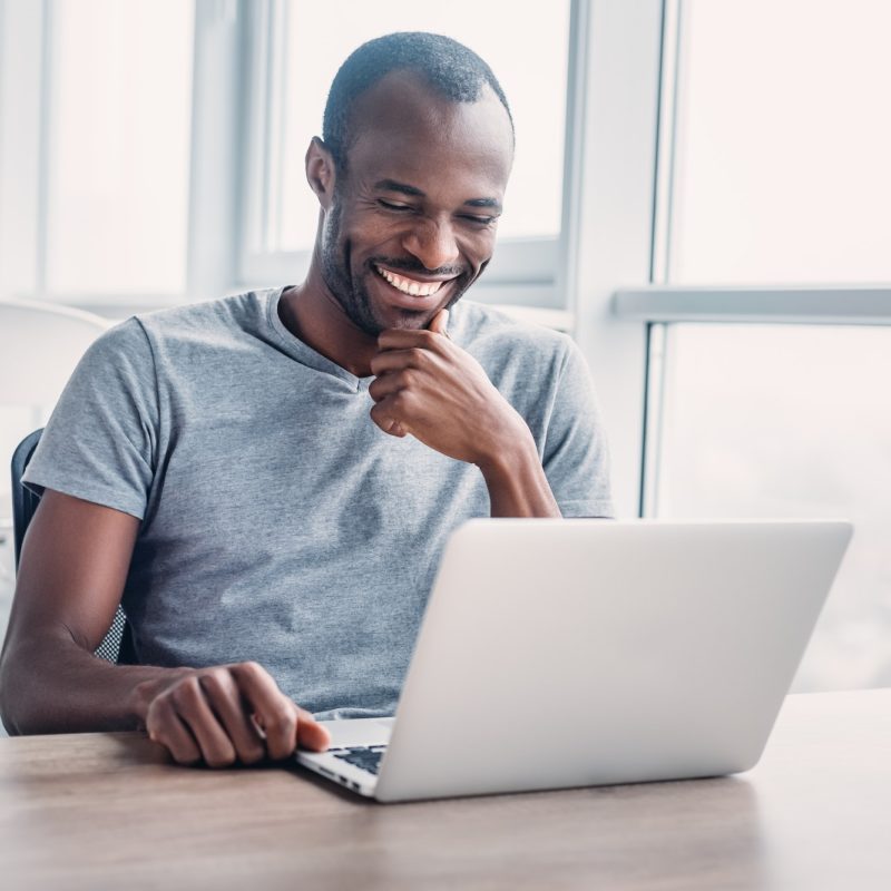 Young businessman working on his laptop in spacious bright office